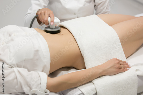 Slim woman getting anticellulite and anti fat therapy in beauty salon