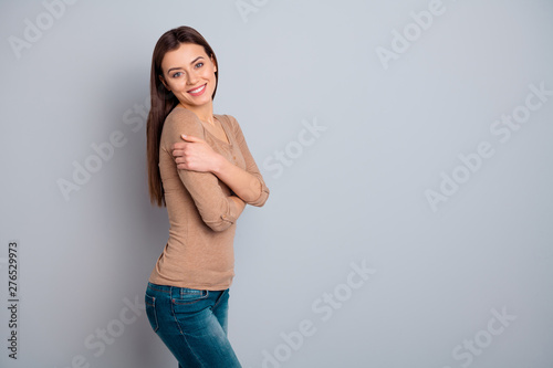 Profile side view portrait of her she nice-looking attractive winsome lovable lovely pretty charming cute cheerful cheery girl hugging herself isolated over gray pastel background