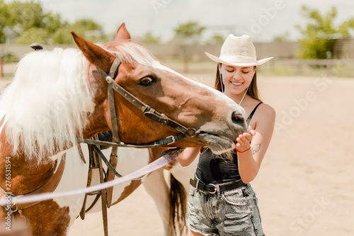 cowgirl feeding her horse on a farm