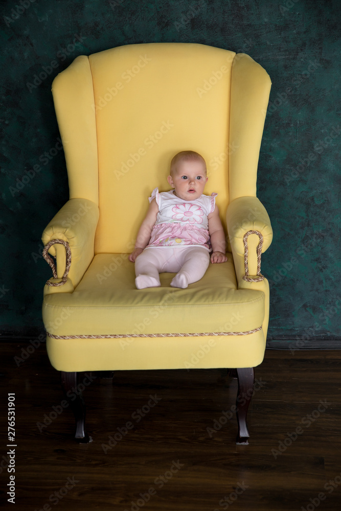 Baby Girl Sitting on Big Armchair in Studio Baby Girl Sitting on Big Armchair in Studio