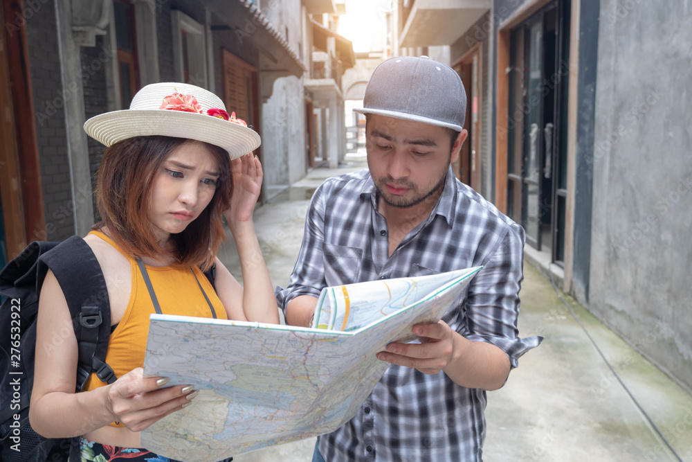 Young Asian couple holding map looking direction on honeymoon vacation. Young Asian couple holding map looking direction on honeymoon vacation.