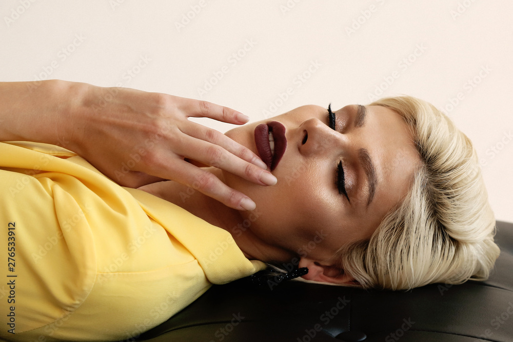 sensual woman with short blond hair in elegant yellow businesslike jacket and pants sensual woman with short blond hair in elegant yellow businesslike jacket and pants