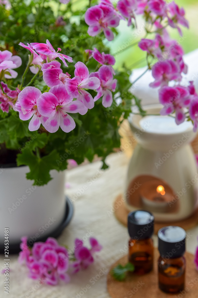 essential oils with rose geranium flower at spa salon