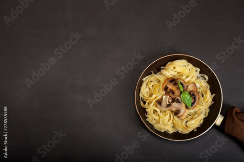 Tagliatelle pasta with fresh mushrooms on black background