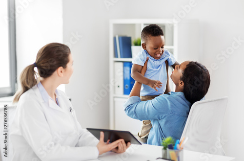medicine  healthcare and pediatry concept - african american mother with baby son and caucasian doctor with tablet computer at clinic