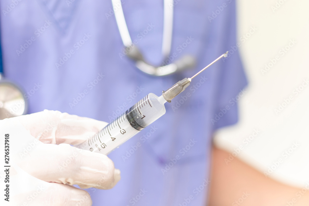 Doctor hand holding injection needle. Medical doctor picking up medication into syringe. Doctor hand holding injection needle. Medical doctor picking up medication into syringe.