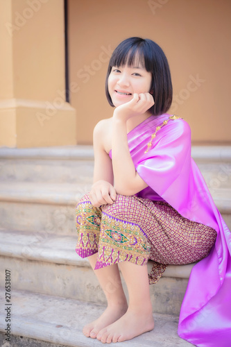 Portrait smiling Asia Girl in Thai Traditional Antique Dress of Old Kingdom in Siam, Southeast Asia.