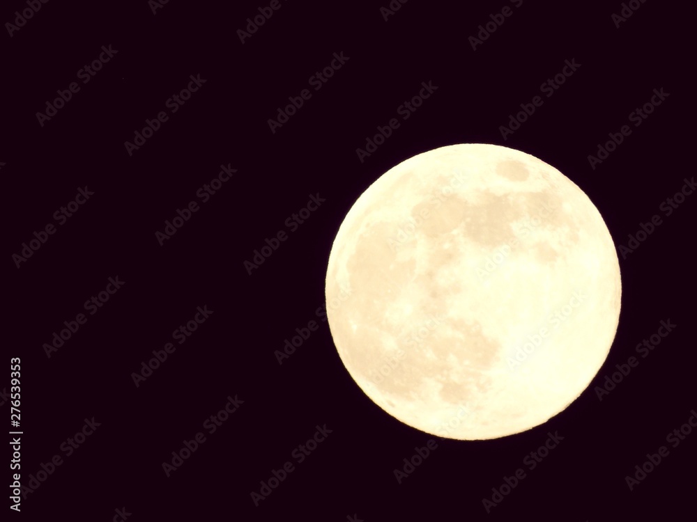Fototapeta premium An amazing photography of the full moon over the city of Genova by night with a great clear and blue sky in the background and some stars.