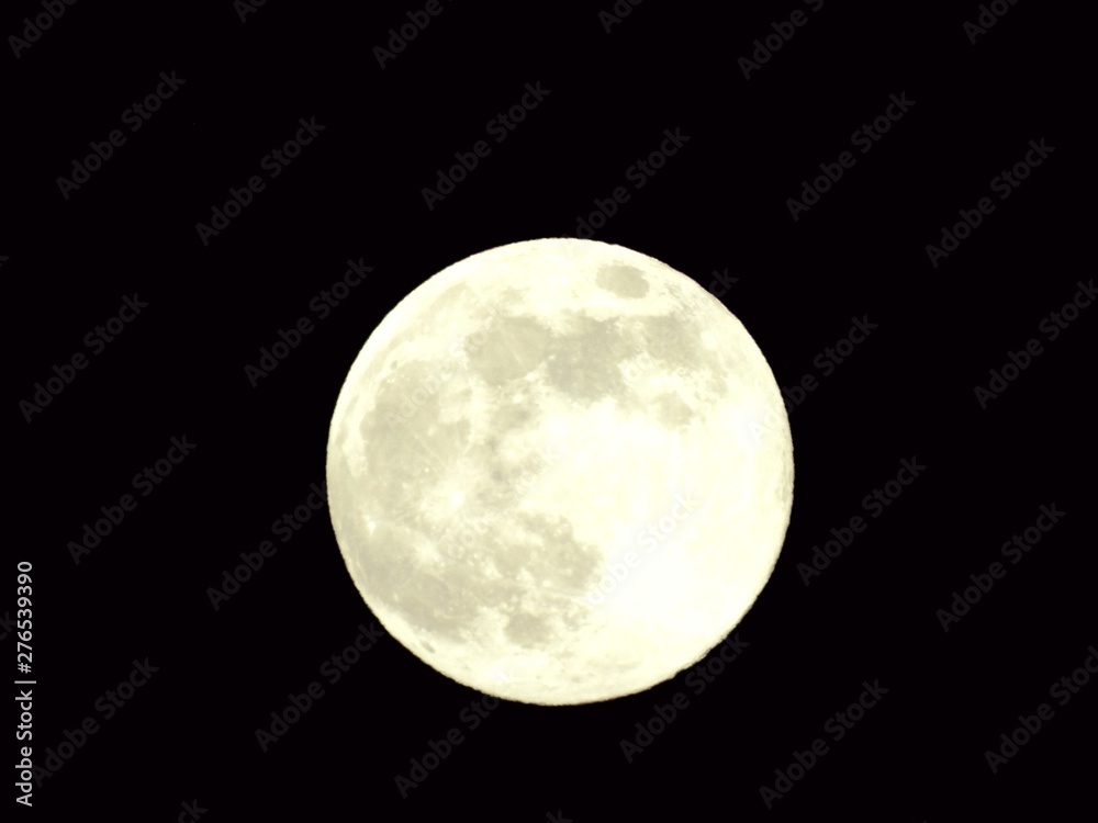 Obraz premium An amazing photography of the full moon over the city of Genova by night with a great clear and blue sky in the background and some stars.