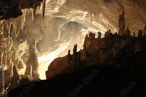 dark interoir of a large cave in Mae Hong Son state, Northern Thailand, viewing the opening from inside, seeing the stalactites and stalagmites  photo
