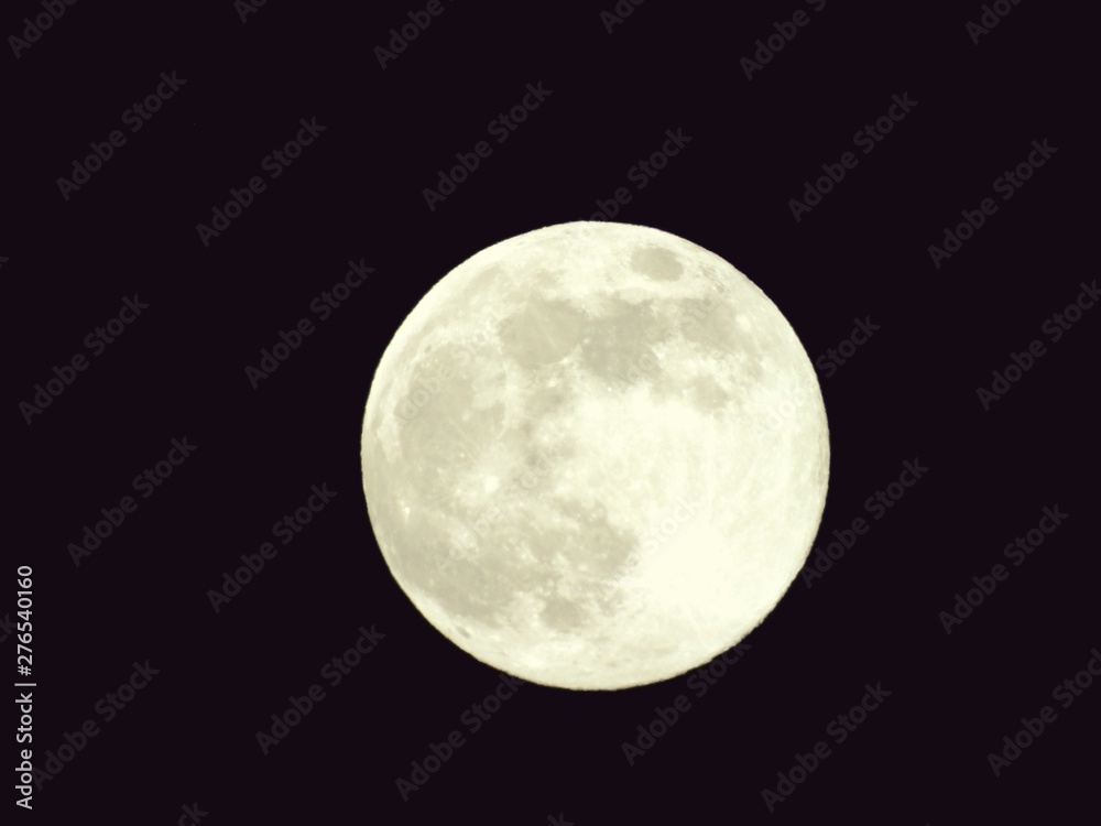 Obraz premium An amazing photography of the full moon over the city of Genova by night with a great clear and blue sky in the background and some stars.
