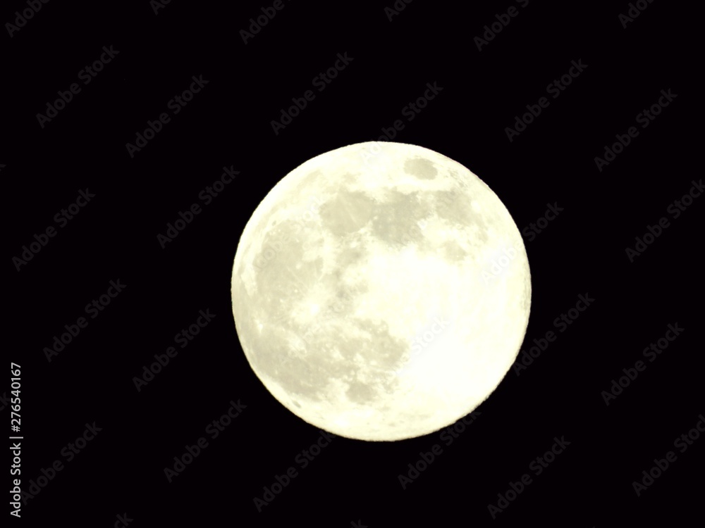 Fototapeta premium An amazing photography of the full moon over the city of Genova by night with a great clear and blue sky in the background and some stars.