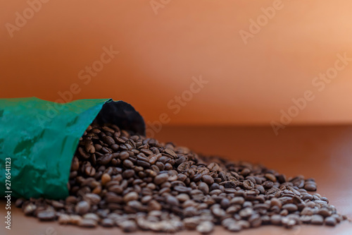 Organic coffee seeds spilled from the bag over the surface. Fresh coffee beans near the bag, isolated.Close up photo