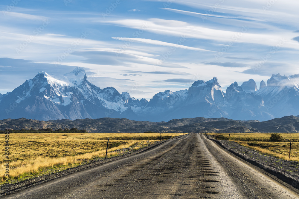 Beautiful view of rural road with golden yellow grass with background of nature cuernos mountains peak with cloud in autumn, Torres del Paine national park, south Patagonia, Chile