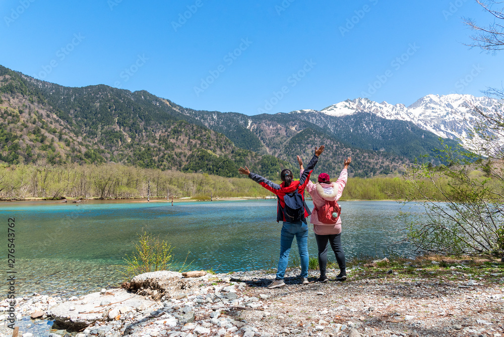 Azusa turquoise color river at Kamikochi in Northern Japan Alps with female hiker.