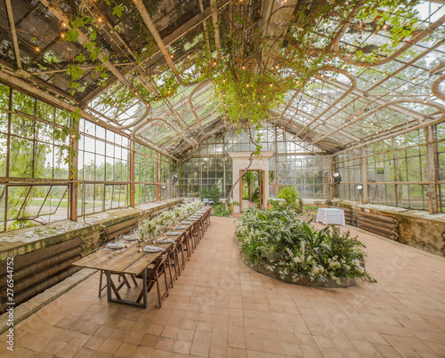 Panoramic photo of a glass room in which plants decorated for a banquet are grown