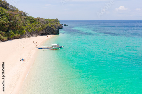 Fototapeta Naklejka Na Ścianę i Meble -  Puka Shell Beach. Wide tropical beach with white sand. Beautiful white beach and azure water on Boracay island, Philippines, top view. Tourists relax on the beach.