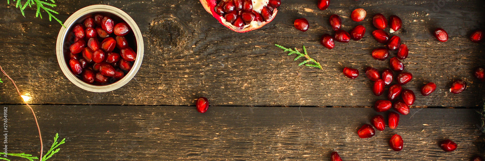 pomegranate fruit red and branches green (vitamin dessert) festive atmosphere. top food background. copy space pomegranate fruit red and branches green (vitamin dessert) festive atmosphere. top food background. copy space