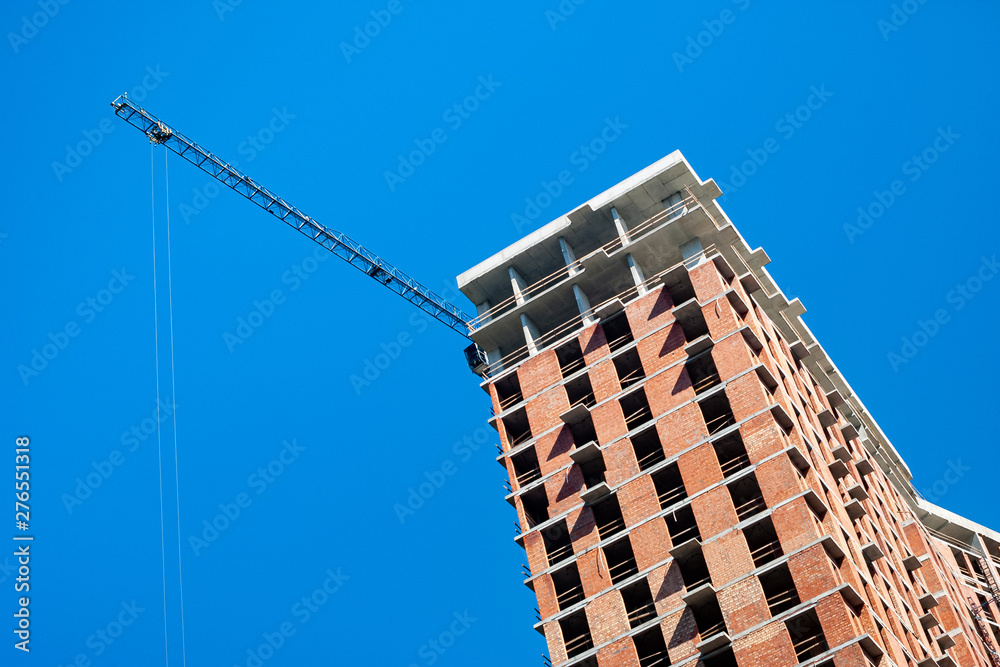 Construction site with crane against the blue sky. Construction site with crane against the blue sky.