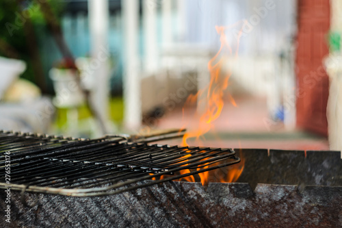 The grid of a grill gets warm on coals