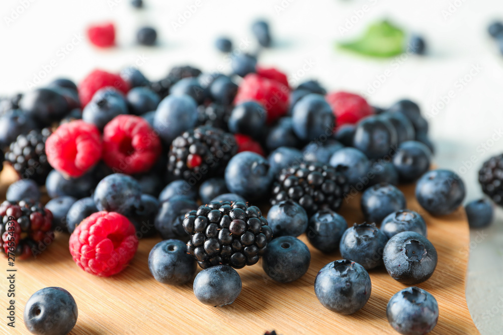 Berries and cutting board on white background, closeup and space for text Berries and cutting board on white background, closeup and space for text