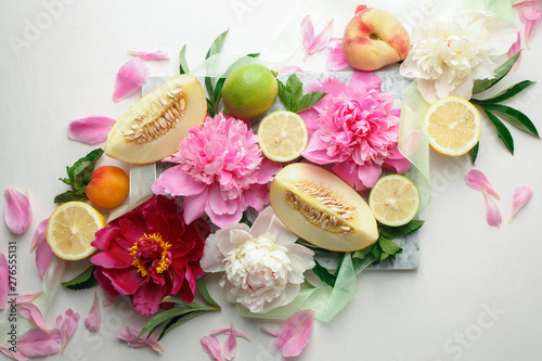 Fototapeta Naklejka Na Ścianę i Meble -  Still life with fresh assorted exotic fruits and peony flowers on white background. Concept of healthy eating with fruits and seasonal flowers. Wedding decor