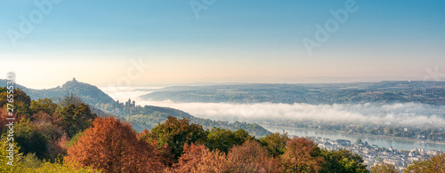  Panoramic view of the hill Drachenfels with the castle ruin, the castle Drachenburg in Siebengebirge and the town Königswinter, morning fog arose from the river Rhine valley, NRW, Germany photo