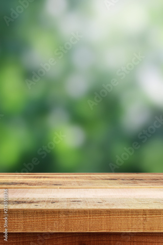 Blurred abstract green bokeh and wooden table background.