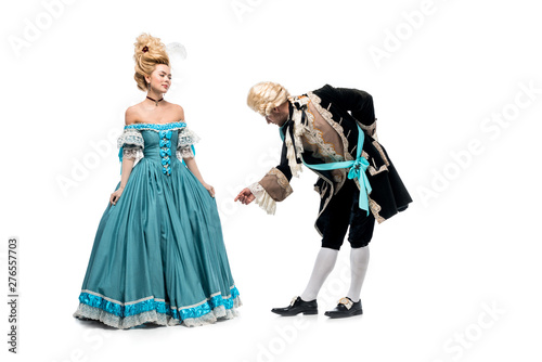 handsome gentleman bowing down near victorian woman in blue dress isolated on white photo