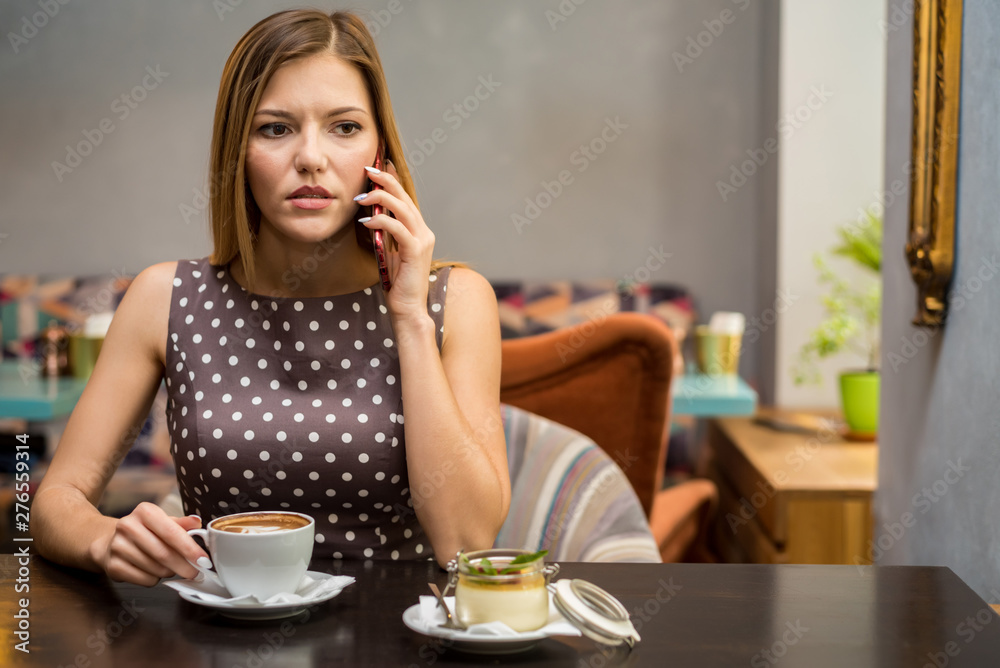 Beautiful serious woman talks on mobile phone in cafe. Portrait picture Beautiful serious woman talks on mobile phone in cafe. Portrait picture