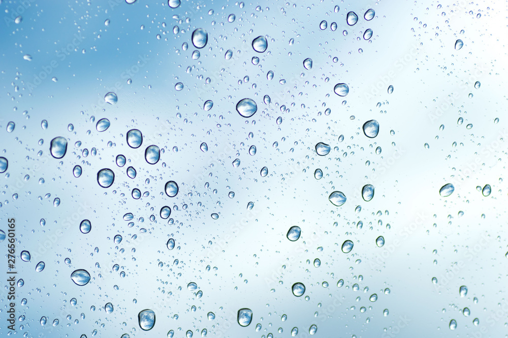 Water drops of rain on blue glass background