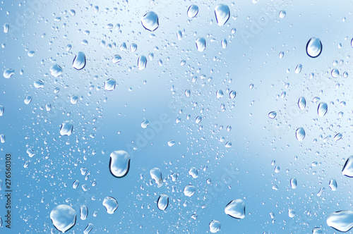 Water drops of rain on blue glass background
