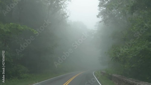 Drive Plate-Narrow curving 2 lane road through heavy fog on a green deciduous forest on the Skyline Drive through Shenandoah National Park in the Blue Ridge Mountains of Virginia-POV Forward