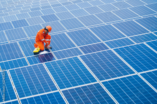 The male employee maintenance panels collect solar energy. Engineer working on checking and maintenance equipment at industry solar power.