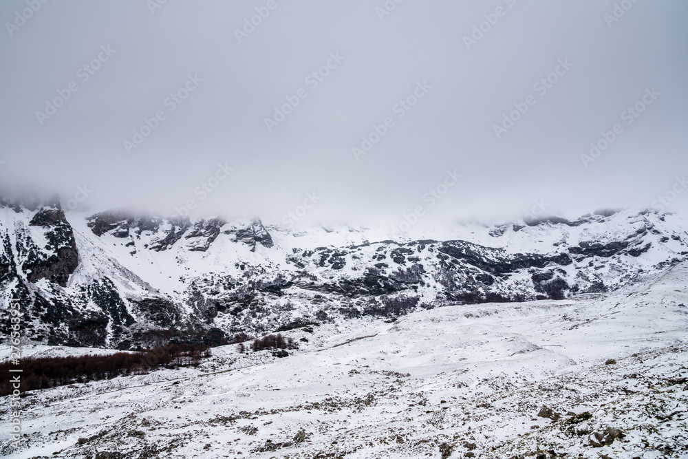 Montenegro, Durmitor highlands and mountain massif hiding in white foggy cloudscape in national park nature landscape covered by snow near zabljak