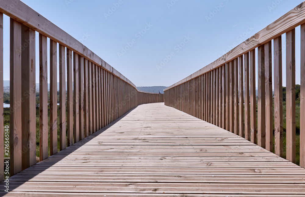 Railed wooden boardwalk at nature reserve Etangs de Villepey, France