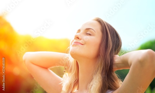 Young relaxed woman on blurred nature background photo