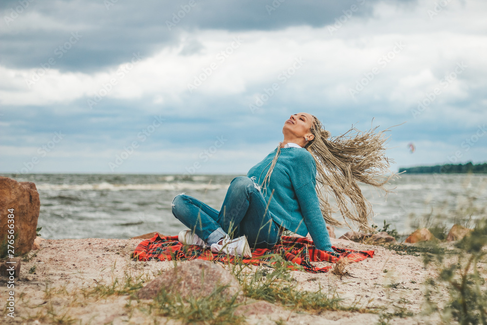 thoughtfully, sad, lonely blonde with pigtails near the sea wrapped in a blanket. loneliness, sadness, depression, sadness, illness thoughtfully, sad, lonely blonde with pigtails near the sea wrapped in a blanket. loneliness, sadness, depression, sadness, illness