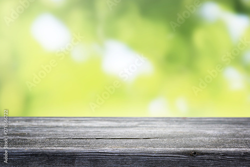 Blurred abstract green yellow bokeh and wooden table background.