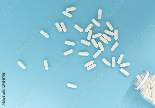 Homeopathic pills and glass bottle on color background. Homeopathic medicine - a homeopathy concept with homeopathic pills. Alternative Homeopathy medicine herbs. Flat lay. Top view. Copy space.  