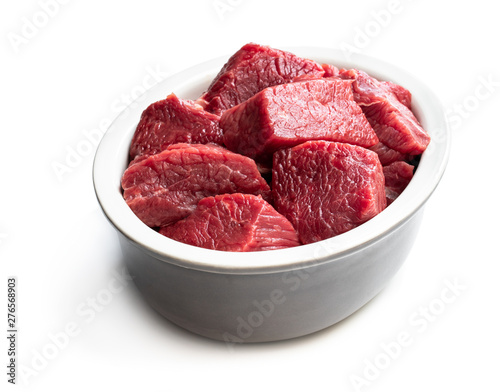 Sliced raw beef in ceramic bowl isolated on white