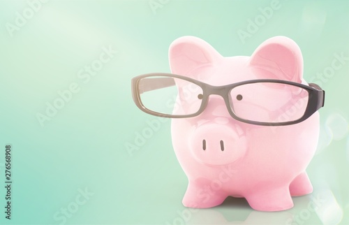 Piggy bank in glasses on background