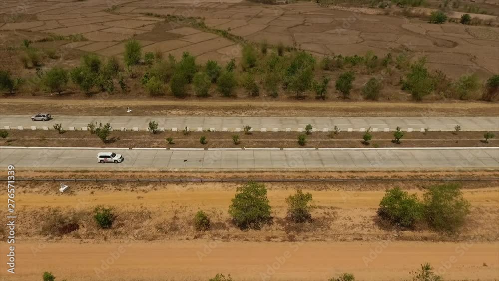 Medium high-angle side-view dolly shot of a speeding white car along the Highway of Death , Yangong-Mandalay Expressway, Myanmar (Burma) Medium high-angle side-view dolly shot of a speeding white car along the Highway of Death , Yangong-Mandalay Expressway, Myanmar (Burma)