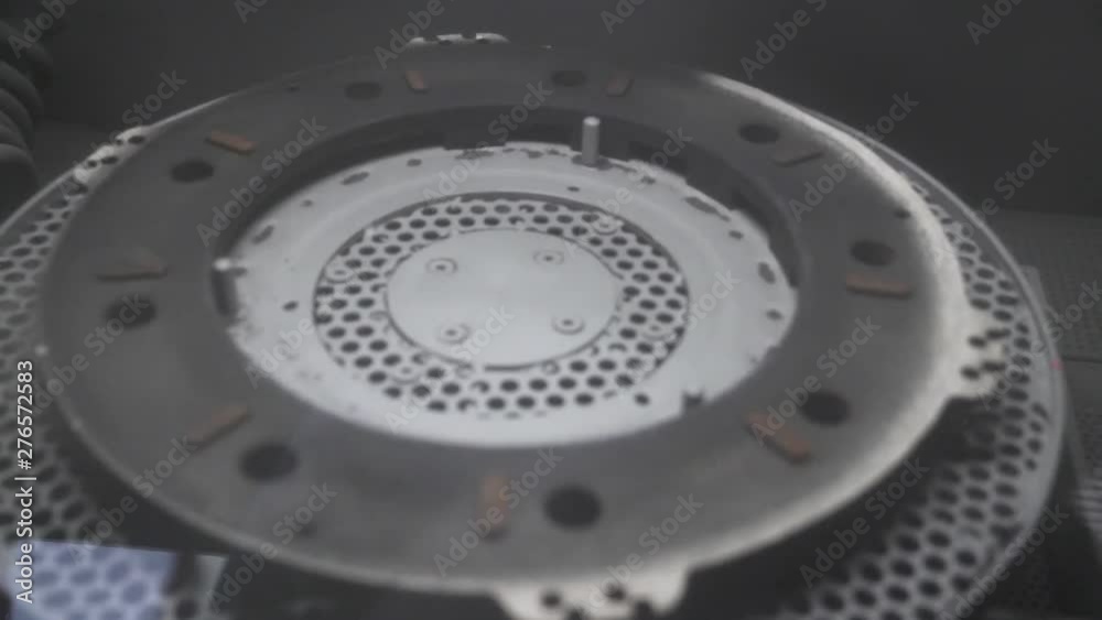 Sanding old metal engine part in a gritter. Sanding old metal engine part in a gritter.