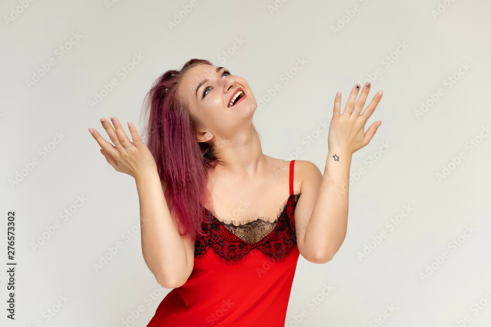 Concept portrait of a pretty sexy girl with purple hair in beautiful red lingerie on a white background. She smiles, happy with life, happy. Hair flying, front view. Made in a studio. Concept portrait of a pretty sexy girl with purple hair in beautiful red lingerie on a white background. She smiles, happy with life, happy. Hair flying, front view. Made in a studio.