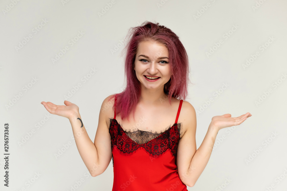 Concept portrait of a pretty sexy girl with purple hair in beautiful red lingerie on a white background. She smiles, happy with life, happy. Hair flying, front view. Made in a studio. Concept portrait of a pretty sexy girl with purple hair in beautiful red lingerie on a white background. She smiles, happy with life, happy. Hair flying, front view. Made in a studio.