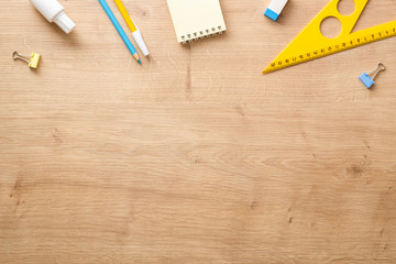 Modern school supplies on wooden desk table background. Back to school concept. Flat lay, top view.