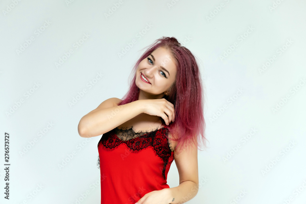 Concept portrait of a pretty sexy girl with purple hair in beautiful red lingerie on a white background. She smiles, happy with life, happy. Hair flying, front view. Made in a studio. Concept portrait of a pretty sexy girl with purple hair in beautiful red lingerie on a white background. She smiles, happy with life, happy. Hair flying, front view. Made in a studio.