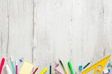 Flat lay school supplies on wooden board. Creative layout with school stationery and copy space, top view. Back to school concept. 