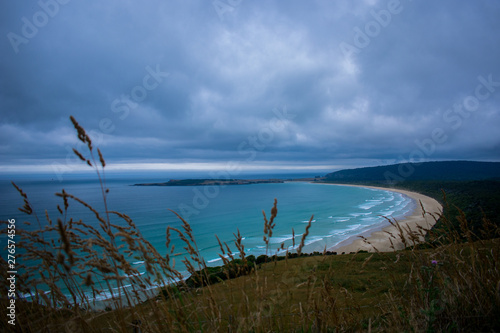 Cielo con tormenta, la bahia y la playa con el oceano